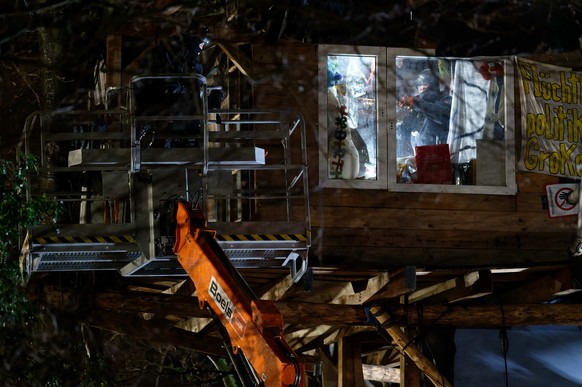 12.01.2023, Nordrhein-Westfalen, Erkelenz: Ein Polizist arbeitet am zweiten Tag der Räumung im von Klimaaktivisten besetzten Braunkohleort Lützerath in einem Baumhaus. Der Energiekonzern RWE will die  ...