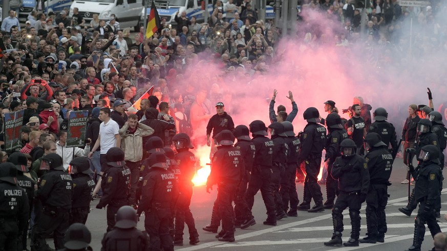 Protesters light fireworks during a far-right demonstration in Chemnitz, Germany, Monday, Aug. 27, 2018 after a man has died and two others were injured in an altercation between several people of &qu ...