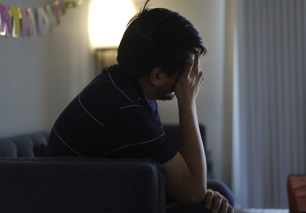 Rahmani, who has been experiencing anxiety and depression since the Trump administration cut federal funding for refugee programs, rubs his eyes while sitting in his apartment in Laurel, Md., Monday, ...