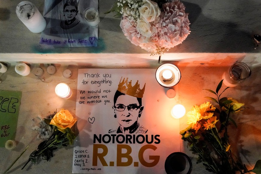 Candles are lit next to pictures of Associate Justice Ruth Bader Ginsburg as people mourn her death at the Supreme Court in Washington, U.S., September 19, 2020. REUTERS/Joshua Roberts