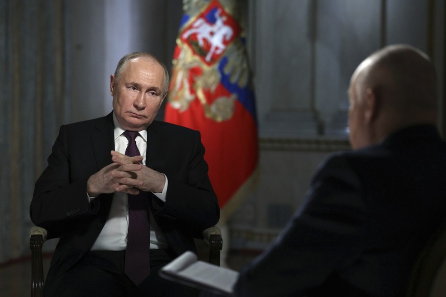 Russian President Vladimir Putin is interviewed by Rossiya Segodnya International Media Group Director General Dmitry Kiselev, back to a camera, in Moscow, Russia, Tuesday, March 12, 2024. (Gavriil Gr ...