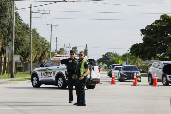 15.09.2024, USA, West Palm Beach: Polizeibeamte leiten den Verkehr in der Nähe des Trump International Golf Club um. Zwei Monate nach dem Attentat auf den früheren US-Präsidenten Donald Trump haben Si ...