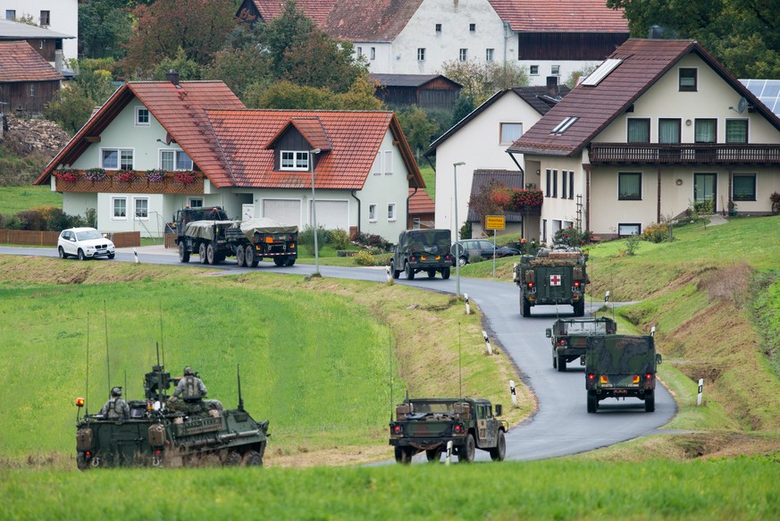 Militärfahrzeuge der US-Armee fahren durch den Ort Kleinfalz nahe dem Truppenübungsplatz Grafenwöhr. 