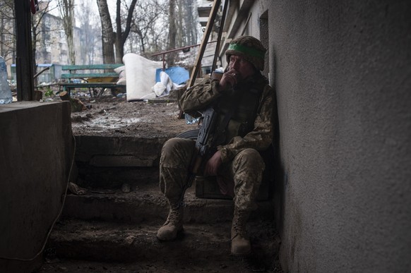 12.04.2023, Ukraine, Bachmut: Ein ukrainischer Soldat raucht, während er sich auf einer Treppe ausruht. Foto: Iryna Rubakova/AP/dpa +++ dpa-Bildfunk +++
