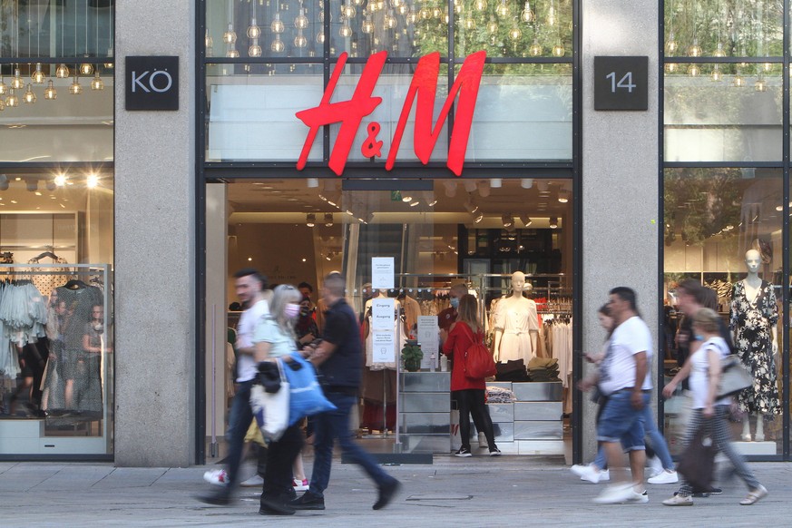 Passanten gehen an einer H &amp; M Hennes Mauritz Filiale in der Fußgängerzone und Einkaufsstraße Königstraße in der Innenstadt von Stuttgart vorbei, Baden Württemberg, Deutschland *** Passers-by walk ...