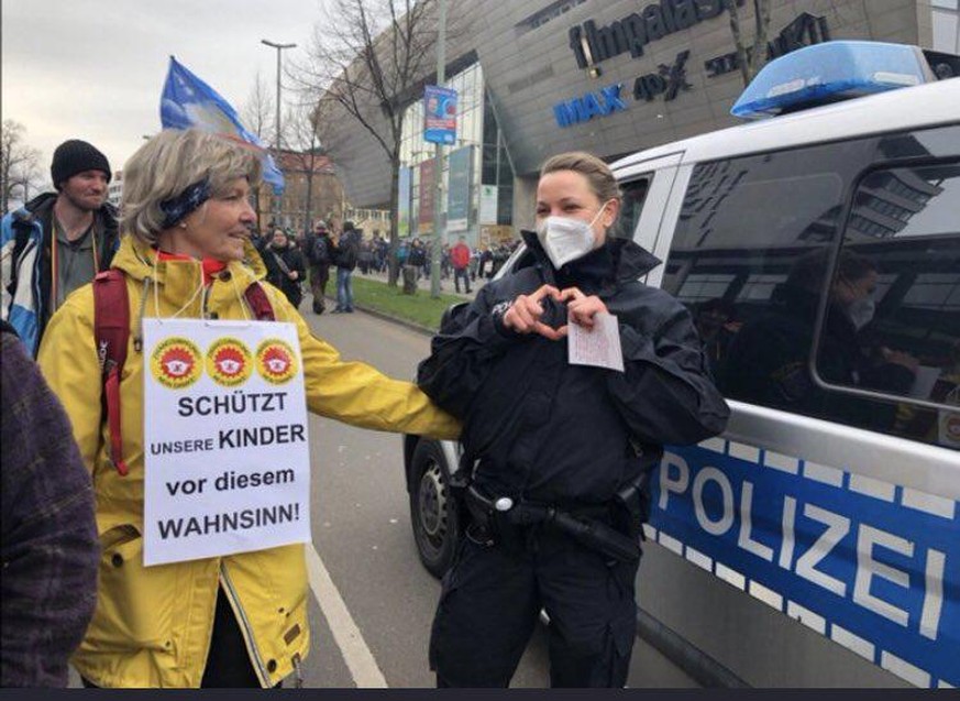 Eine Polizeibeamtin solidarisiert sich augenscheinlich mit einer Frau, die gegen die Corona-Maßnahmen demonstriert. Nicht nur dieses Bild von der Demo in Kassel sorgt für Empörung.