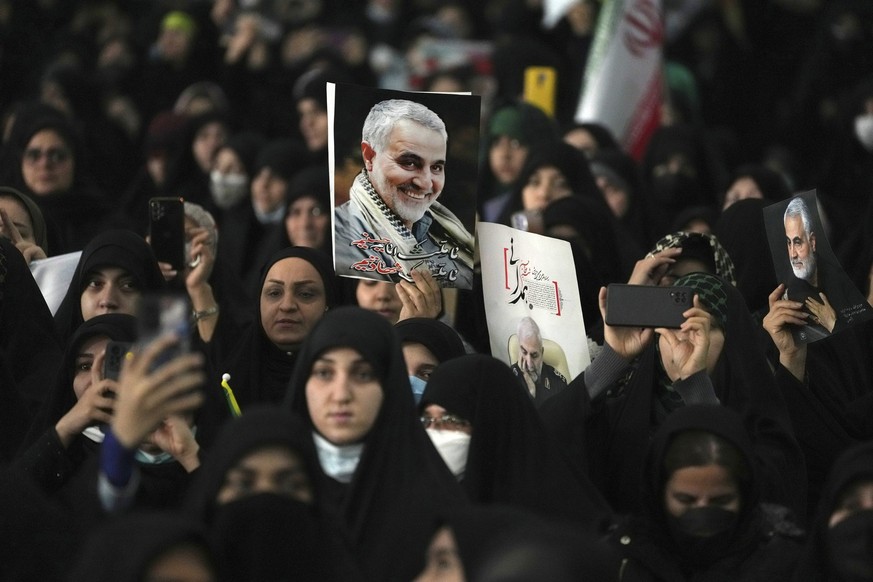 dpatopbilder - 03.01.2023, Iran, Teheran: Trauernde nehmen an einer Zeremonie anlässlich des Todestages des verstorbenen Generals der Revolutionsgarden Soleimani (auf den Plakaten) teil, der 2020 im I ...