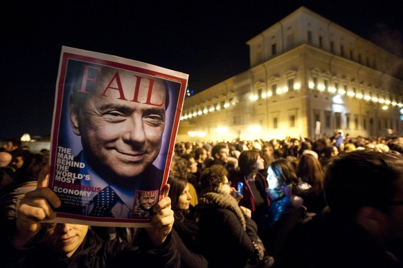 "Der Mann hinter der gefährlichsten Wirtschaft der Welt" steht auf disem Zeitschriftencover, das am Abend des 12. November 2011 eine Frau in Rom in die Kamera hält.