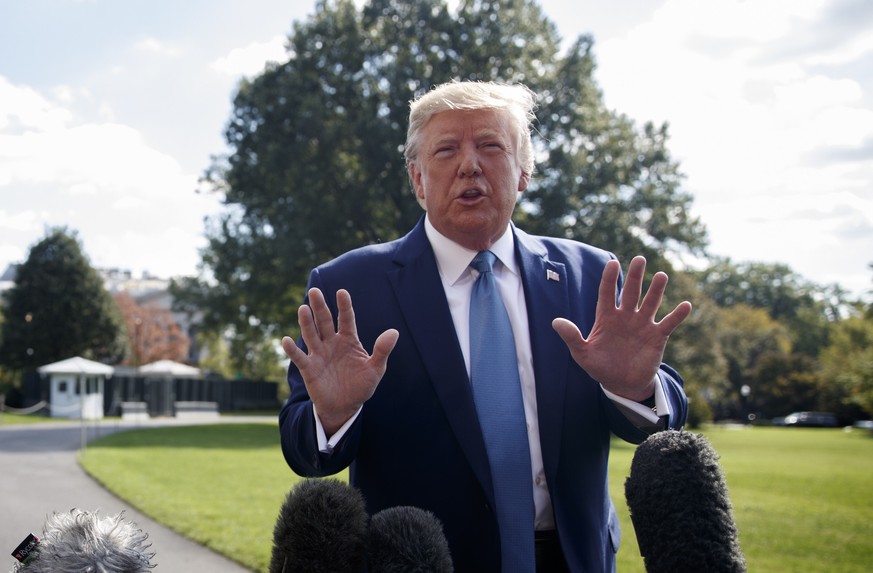 US President Donald J Trump responds to a question from the news media as he walks to board Marine One on the South Lawn of the White House in Washington, DC, on Friiday, October 4, 2019. President Tr ...
