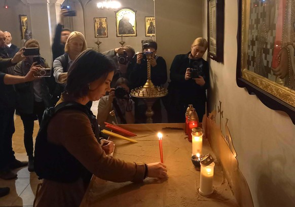 (RECROP) Außenministerin Annalena Baerbock (M, Bündnis 90/Grüne) entzündet eine Kerze für die Opfer in einer Kirche in Butscha. Große Teile nördlich und nordwestlich von Kiew waren einen Monat lang vo ...