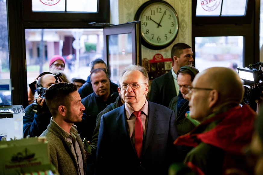 Reiner Haseloff (CDU, m.), Ministerpräsident des Landes Sachsen-Anhalt, wird vom Izzet Cagac (l.), dem bisherigen Betreiber des Imbisses "Kiez-Döner", empfangen.