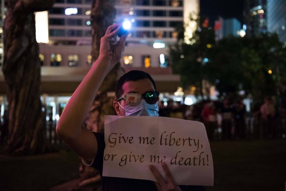 Proteste in Hongkong August 30, 2019, Hong Kong, Hong Kong Island, China: A protester holds a placard supporting Hong Kong and the anti-extradition movement during the commemoration..Protesters gather ...