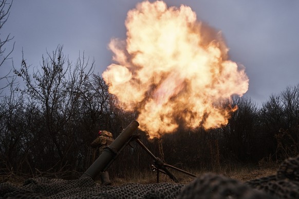 22.12.2022, Ukraine, Bachmut: Ukrainische Soldaten feuern einen Mörser auf russische Stellungen. Foto: Libkos/AP/dpa +++ dpa-Bildfunk +++
