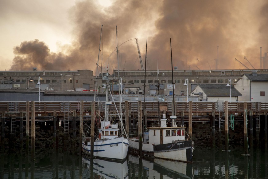 The Liberty ship SS Jeremiah O&#039;Brien appears through the clearing smoke of a four-alarm fire burning on Pier 45 in San Francisco on Saturday, May 23, 2020. (Karl Mondon/Bay Area News Group/TNS) P ...