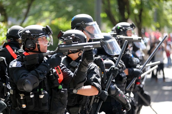 Police prepare to push back against protesters Saturday, Aug. 4, 2018, in Portland, Ore. Small scuffles broke out Saturday as police in Portland, Oregon, deployed "flash bang" devices and ot ...