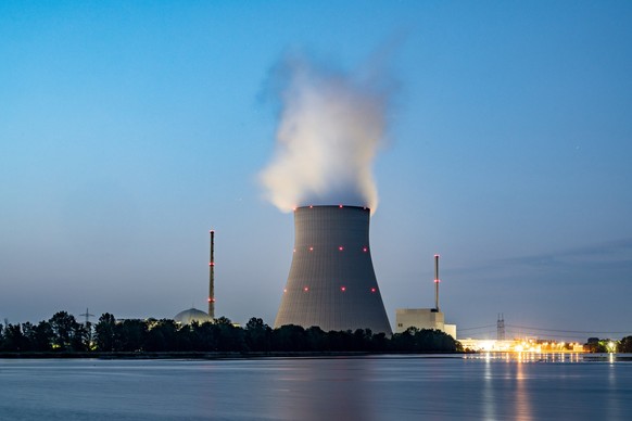 ARCHIV - 21.07.2022, Bayern, Essenbach: Wasserdampf steigt aus dem K�hltum vom Atomkraftwerk (AKW) Isar 2. Zwei der drei letzten deutschen Atomkraftwerke sollen laut Bundeswirtschaftsminister Habeck ( ...
