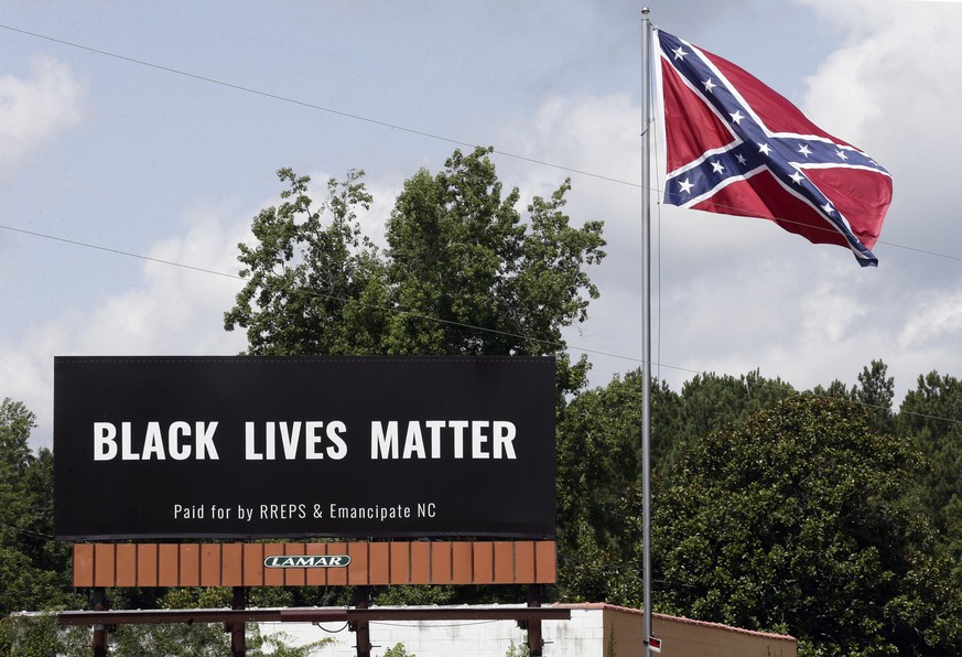 Ein Black Lives Matter-Plakat ist neben einer U-Konföderiertenflagge zu sehen.