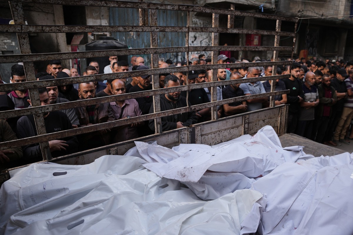 Palestinians pray over the bodies of people killed in an Israeli military strike during their funeral at Al-Awda Hospital in Nuseirat, central Gaza Strip, Wednesday, Oct. 29, 2025. (AP Photo/Abdel Kar ...