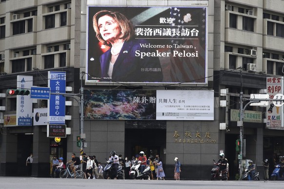 FILE - People walk past a billboard welcoming U.S. House Speaker Nancy Pelosi, in Taipei, Taiwan, Aug 3, 2022. Days after Ayman al-Zawahiri was killed in Kabul, China staged large-scale military exerc ...