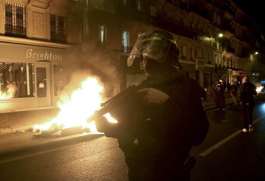 24.11.2020, Frankreich, Paris: Ein Polizist steht w