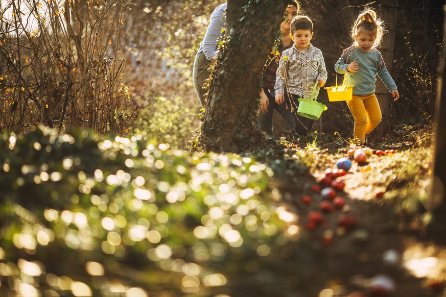 Cute little kids and their moms during Easter egg hunt