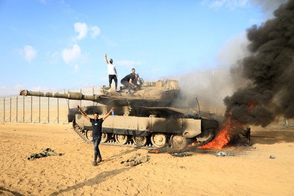 231007 -- GAZA, Oct. 7, 2023 -- Palestinians are seen near an Israeli tank, near the fence of the Gaza-Israel border, east of the southern Gaza Strip city of Khan Younis, Oct. 7, 2023. TO GO WITH 3rd  ...