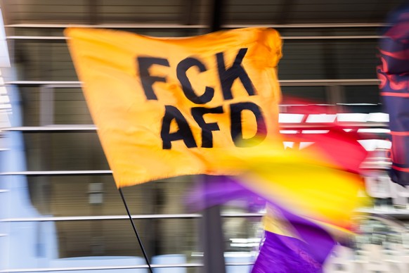 22.09.2024, Brandenburg, Potsdam: Eine Anti-AfD-Fahne mit der Aufschrift «FCK AFD» wird bei einem Protest gegen die Wahlparty und rechte Politik der AfD vor dem Potsdamer Hauptbahnhof geschwenkt. In B ...