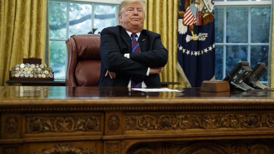 President Donald Trump crosses his arms after speaking with Mexican President Enrique Pena Nieto on the phone about a trade agreement between the United States and Mexico, in the Oval Office of the Wh ...