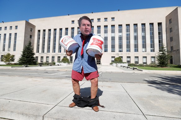 An activist costumed as U.S. Supreme Court nominee Brett Kavanaugh holds prop beer cans as activists gather for a protest march and rally in opposition to Kavanaugh's nomination outside U.S. District  ...