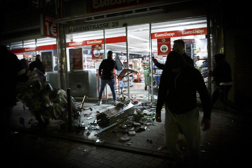 dpatopbilder - 21.06.2020, Baden-Württemberg, Stuttgart: Menschen stehen vor einem geplünderten Geschäft in der Marienstraße. Bei Auseinandersetzungen mit der Polizei haben dutzende gewalttätige Klein ...