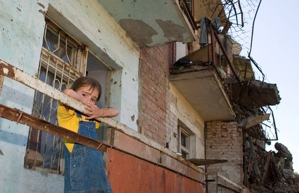 Ein Mädchen blickt über den Balkon eines zerstörten Wohnblocks in Grozny, der Hauptstadt von Tschetschenien.