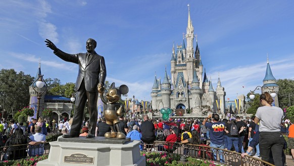 ARCHIV - 09.01.2019, USA, Lake Buena Vista: Eine Statue von Walt Disney und Micky Maus steht vor dem Cinderella-Schloss im Magic Kingdom von Walt Disney World. Disney hat den Gouverneur des US-Bundess ...