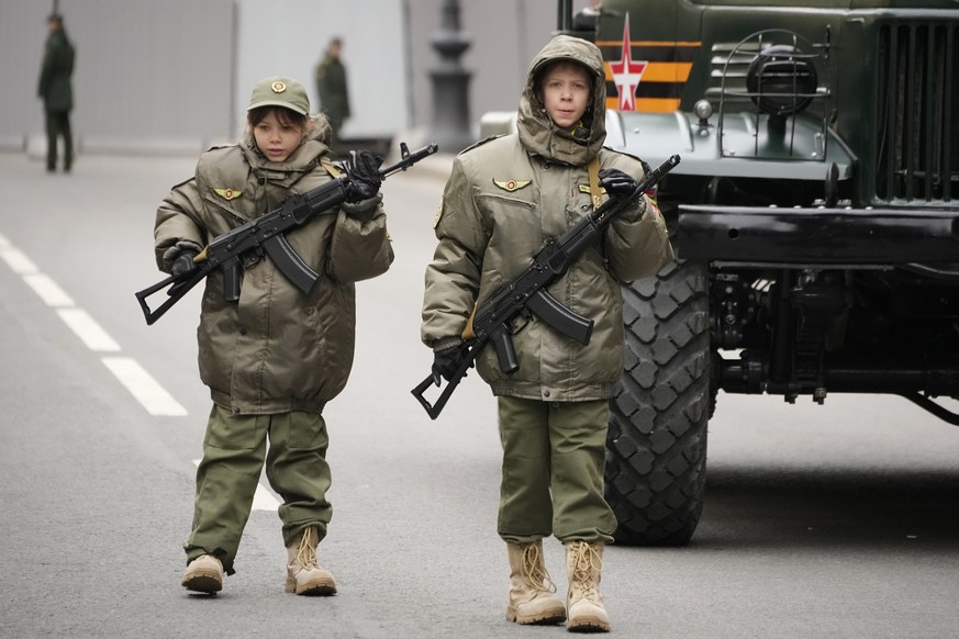 ARCHIV - 05.05.2024, Russland, St. Petersburg: Zwei Kinder, die an der Parade teilnehmen, gehen mit Waffen zu einer Probe für die Militärparade zum Tag des Sieges auf dem Dvortsovaya (Palast)-Platz. D ...