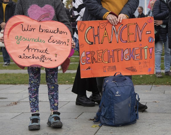 15.10.2022, Berlin: Ein Kind hält bei der Kundgebung der Initiative #ichbinarmutsbetroffen am Bundeskanzleramt ein Plakat mit der Aufschrift «Wir brauchen gesundes Essen! Armut abschaffen!» - eine Fra ...