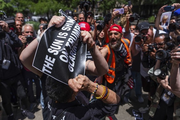 30.05.2024, USA, New York: Ein Anhänger des ehemaligen US-Präsidenten Trump und ein Trump-Gegner streiten sich vor dem Strafgericht in Manhattan. Die Beratungen der Geschworenen in Trumps Schweigegeld ...