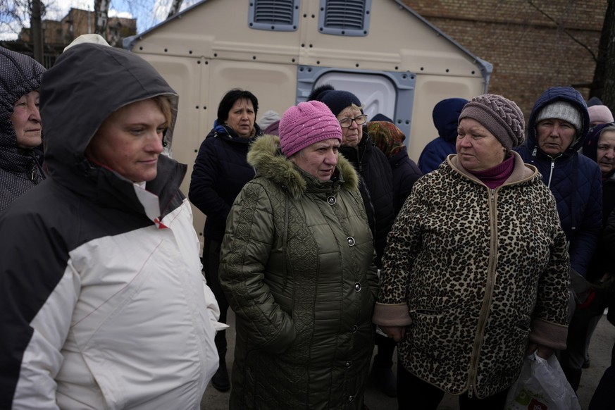 Women wait for a food distribution in Horenka, outskirts of Kyiv, Ukraine, Sunday, March 5, 2023. (AP Photo/Thibault Camus)