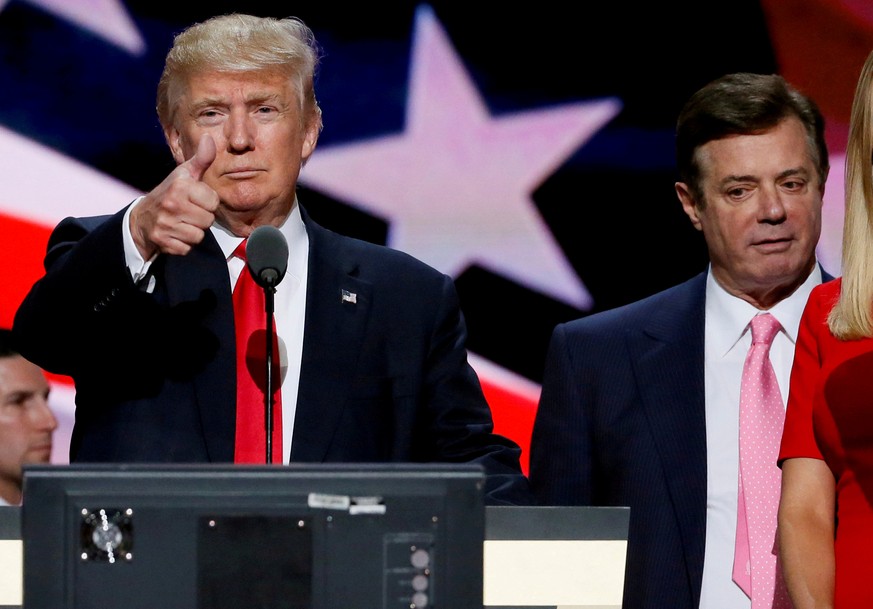 FILE PHOTO: Then-Republican presidential nominee Donald Trump gives a thumbs up as his campaign manager Paul Manafort looks on during Trump&#039;s walk through at the Republican National Convention in ...