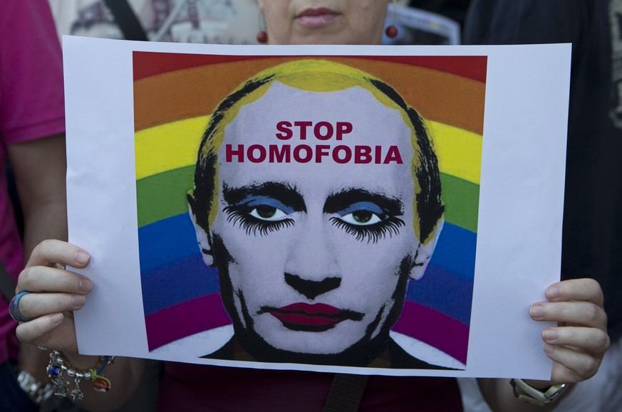 FILE - A woman holds a poster depicting Russian President Vladimir Putin during a protest in front of the Russian embassy in Madrid, Spain, Friday Aug. 23, 2013 against Russia&#039;s new law on gays.  ...