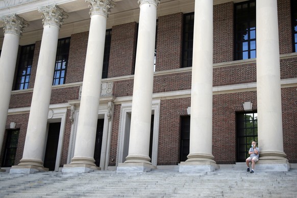 A man wearing a face mask in concern for the coronavirus, talks on his phone, Friday, June 26, 2020, on the steps of Harvard University&#039;s Widener Library, in Cambridge, Mass. (AP Photo/Elise Amen ...