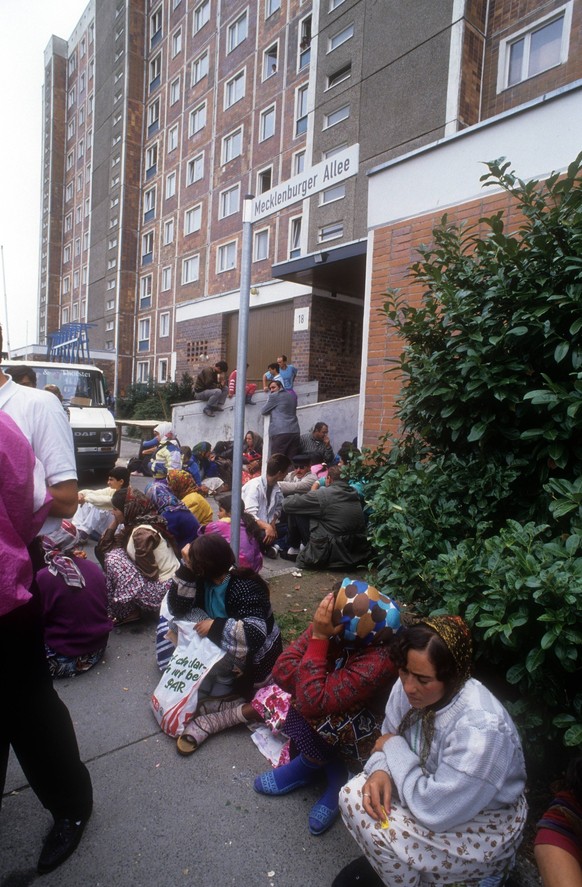 Reportage Ausschreitungen Rostock Lichtenhagen 1992, auf dem Gehweg ausharrende Flüchtlinge
Reportage Riots Rostock Lichtenhagen 1992 on the Sidewalk Refugees