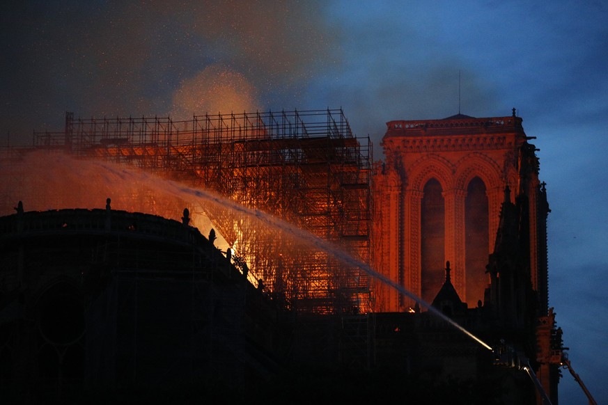 Firefighters use hoses as Notre Dame cathedral burns in Paris, Monday, April 15, 2019. A catastrophic fire engulfed the upper reaches of Paris' soaring Notre Dame Cathedral as it was undergoing renova ...