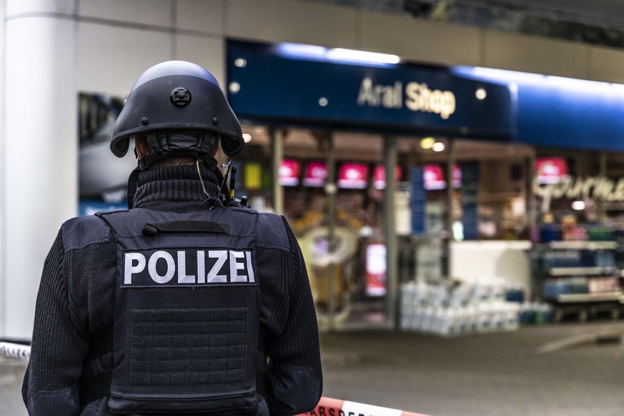 19.09.2021, Rheinland-Pfalz, Idar-Oberstein: Ein Polizist sichert am frühen Morgen eine Tankstelle. Ein Angestellter der Tankstelle war in Idar-Oberstein in Rheinland-Pfalz von einem mit einer Pistole ...