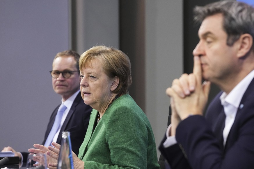 German Chancellor Angela Merkel speaks as Berlin's Governing Mayor Michael Muller, left, and Bavaria's Prime Minister Markus Soder, right, listen during a press conference in the Chancellor's Office f ...