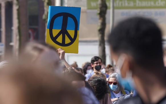 Ein Schild mit dem Zeichen für Frieden in den Farben der Ukraine.