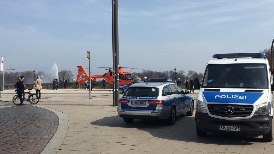 12.04.2018, Hamburg: Einsatzfahrzeuge der Polizei und ein Rettungshubschrauber stehen am Jungfernstieg. In der Hamburger Innenstadt ist am Donnerstag bei einem Messerangriff ein Kind erstochen und ein ...