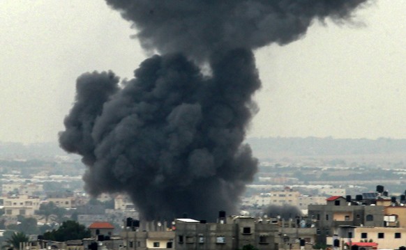 Smoke rises above buildings, in the southern Gaza Strip, following an Israeli strike, on Monday October 9, 2023. The Israeli army said it hit more than 500 targets in the Gaza Strip in overnight strik ...