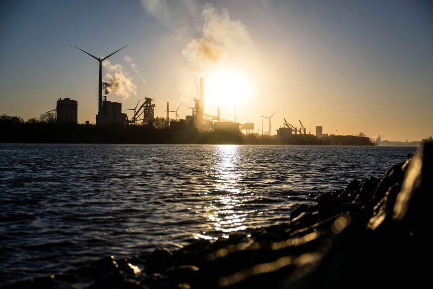03.04.2023, Bremen: Das Stahlwerk an der Weser im Sonnenaufgang. Das Stahlwerk von ArcelorMittal in Bremen soll auf die Produktion von sogenanntem gr