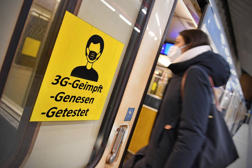 FOTOMONTAGE: Oeffentlicher Personenverkehr in Bussen und Bahnen nur noch nach der 3G Regel-Geimpft,Genesen,Getestet Einfuehrung FFP2 Maskenpflicht im oeffentlichen Personennahverkehr. Junge Frau steig ...