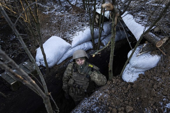 dpatopbilder - 11.01.2023, Ukraine, Bachmut: Ein ukrainischer Soldat raucht eine Zigarette in einem Schützengraben an der Frontlinie in der Nähe von Bachmut. Foto: Evgeniy Maloletka/AP/dpa +++ dpa-Bil ...