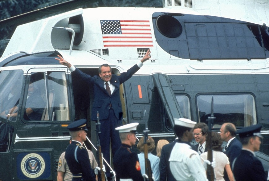 DISTRICT OF COLUMBIA, UNITED STATES - 9th AUGUST 1974: President Richard Nixon with arms outstretched with veed fingers at doorway to helicopter as he departs after his resignation with others on grou ...